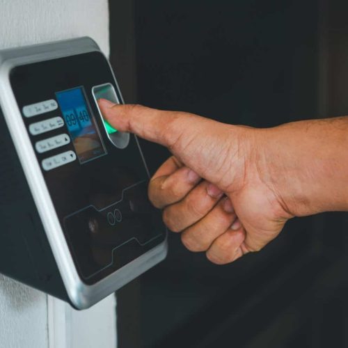 A person is using a fingerprint reader to access a building