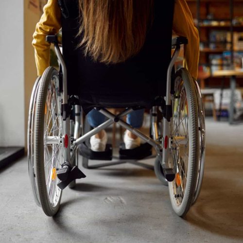 Disabled female student in wheelchair, back view
