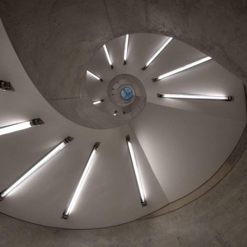 Spiral staircase glowing with modern fluorescent tube lighting